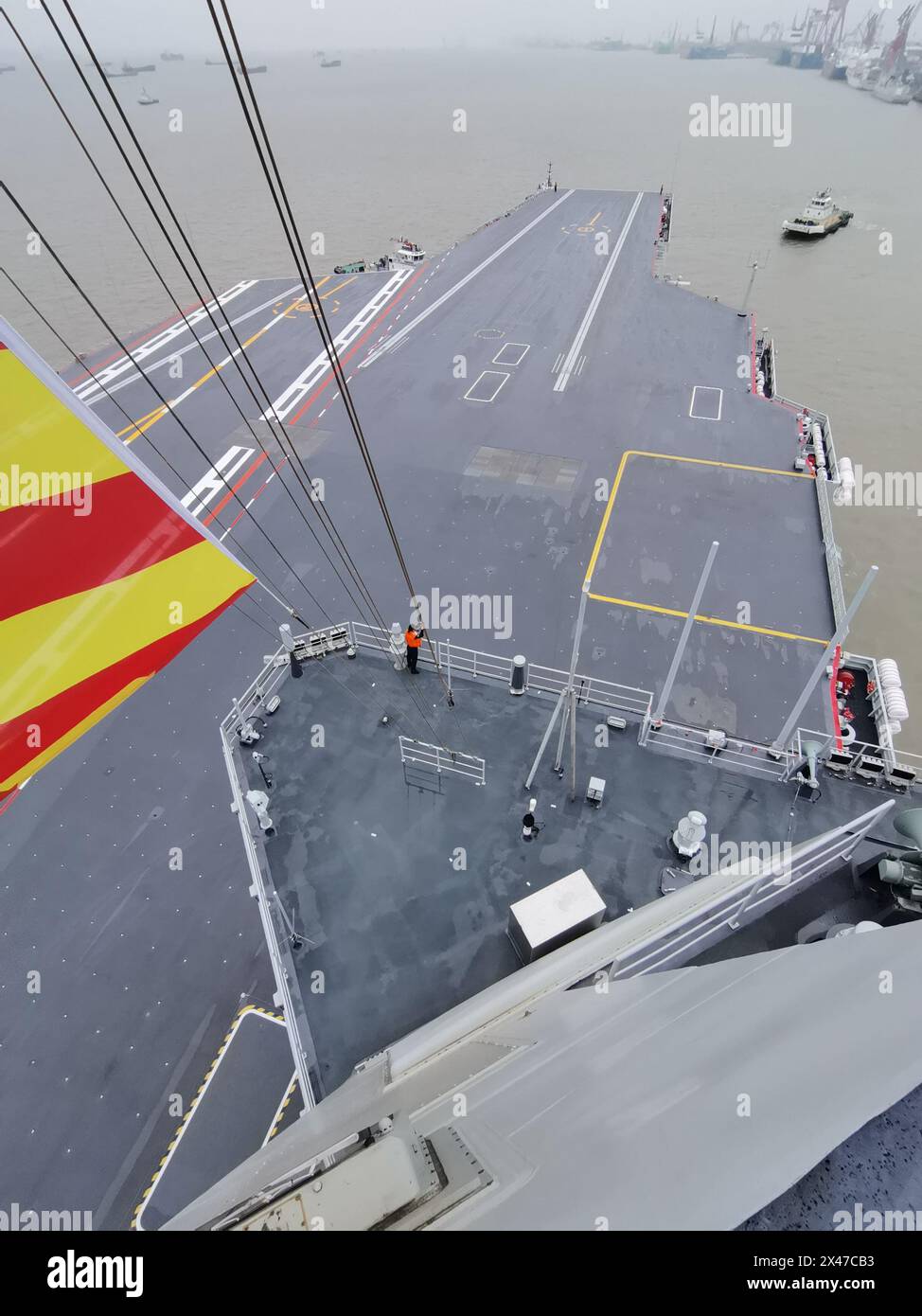 Shanghai, Fujian. 1 maggio 2024. Un rimorchiatore getta la terza portaerei cinese, la Fujian, lontano da un molo nella zona orientale di Shanghai il 1° maggio 2024. La terza portaerei cinese, la Fujian, è partita per le prime prove in mare mercoledì mattina. Le prove in mare testeranno principalmente l'affidabilità e la stabilità dei sistemi elettrici e di propulsione della portaerei. Dal suo lancio nel giugno 2022, il Fujian ha completato le prove di ormeggio, i lavori di allestimento e le regolazioni delle attrezzature. Ha soddisfatto i requisiti tecnici per le prove in mare. Crediti: Li Tang/Xinhua/Alamy Live News Foto Stock