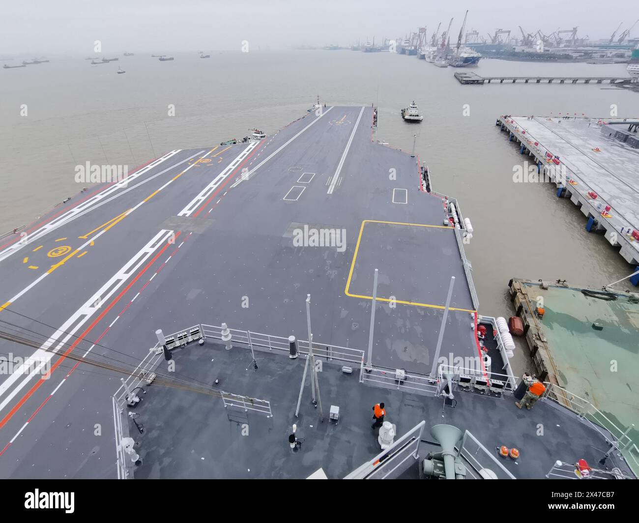 Shanghai, Fujian. 1 maggio 2024. Un rimorchiatore getta la terza portaerei cinese, la Fujian, lontano da un molo nella zona orientale di Shanghai il 1° maggio 2024. La terza portaerei cinese, la Fujian, è partita per le prime prove in mare mercoledì mattina. Le prove in mare testeranno principalmente l'affidabilità e la stabilità dei sistemi elettrici e di propulsione della portaerei. Dal suo lancio nel giugno 2022, il Fujian ha completato le prove di ormeggio, i lavori di allestimento e le regolazioni delle attrezzature. Ha soddisfatto i requisiti tecnici per le prove in mare. Crediti: Li Tang/Xinhua/Alamy Live News Foto Stock