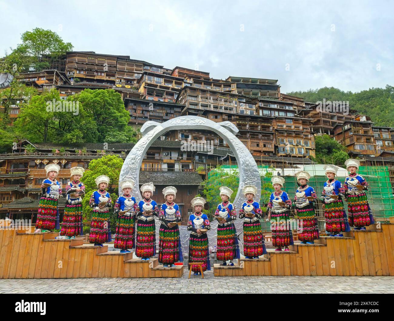 Pechino, la provincia cinese di Guizhou. 30 aprile 2024. I membri del personale di un punto panoramico salutano i turisti al villaggio Xijiang Qianhu Miao nella contea di Leishan di Qiandongnan Miao e nella prefettura autonoma di Dong, nella provincia di Guizhou, nella Cina sud-occidentale, il 30 aprile 2024. Il villaggio ha tenuto molte attività come partite di basket, spettacoli di costumi e spettacoli di canto e danza per accogliere i turisti. Crediti: Liu Xu/Xinhua/Alamy Live News Foto Stock