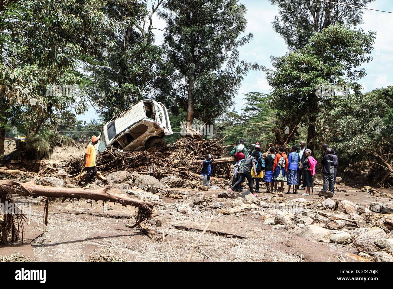 Nakuru, Kenya. 30 aprile 2024. Le persone si riuniscono accanto a un'auto danneggiata che è stata gettata sopra i detriti da acque infuriate. Le operazioni di ricerca e salvataggio sono in corso a seguito di una tragedia alluvionale a mai Mahiu, nella contea di Nakuru. Più di 50 persone sono state dichiarate morte. Credito: SOPA Images Limited/Alamy Live News Foto Stock