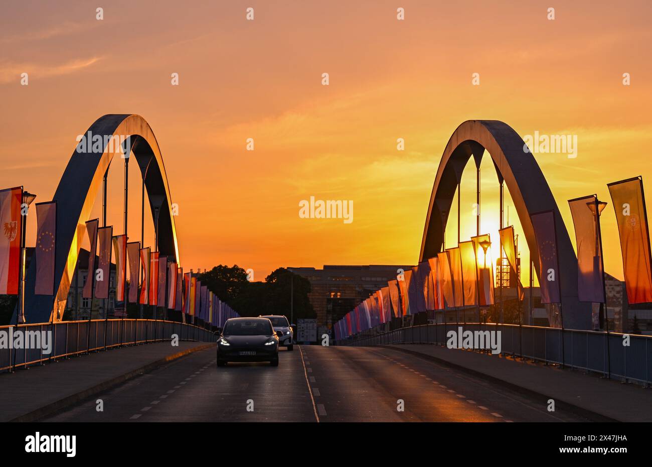 01 maggio 2024, Brandeburgo, Francoforte (Oder): Le auto attraversano il ponte cittadino sul fiume Oder tra Francoforte (Oder) e Slubice in Polonia all'alba. In occasione del ventesimo anniversario dell'adesione della Polonia all'Unione europea, i ministri degli Esteri dei due paesi vicini vogliono riunirsi a mezzogiorno. Entrambi vogliono visitare il Collegium Polonicum a Slubice sul lato polacco, nonché un festival europeo, e poi camminare insieme attraverso il ponte della città sul confine tedesco-polacco fiume Oder fino a Francoforte (Oder). Foto: Patrick Pleul/dpa Foto Stock