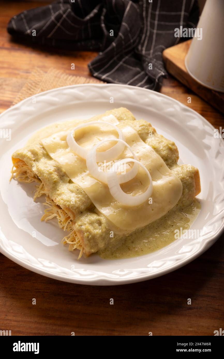 Cibo messicano. Enchiladas con salsa verde cremosa ripiena di carne di pollo grattugiata e ricoperta di formaggio fuso, in Messico si chiamano Swiss Enc Foto Stock