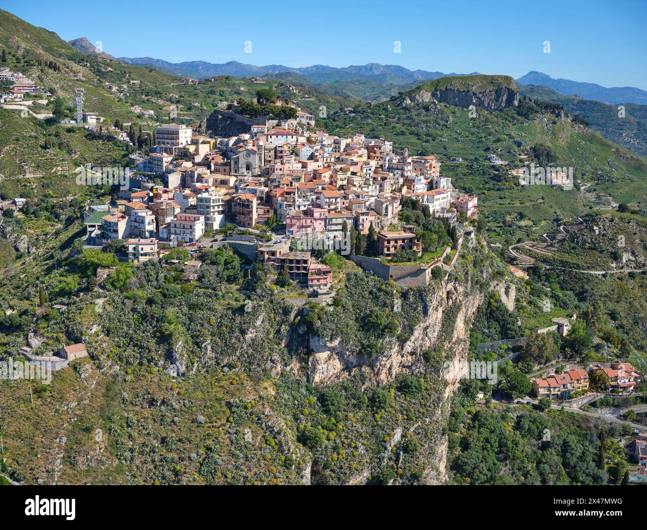 VISTA AEREA. Borgo medievale di Castelmola in cima a una collina. Città metropolitana di Catania, Sicilia, Italia. Foto Stock