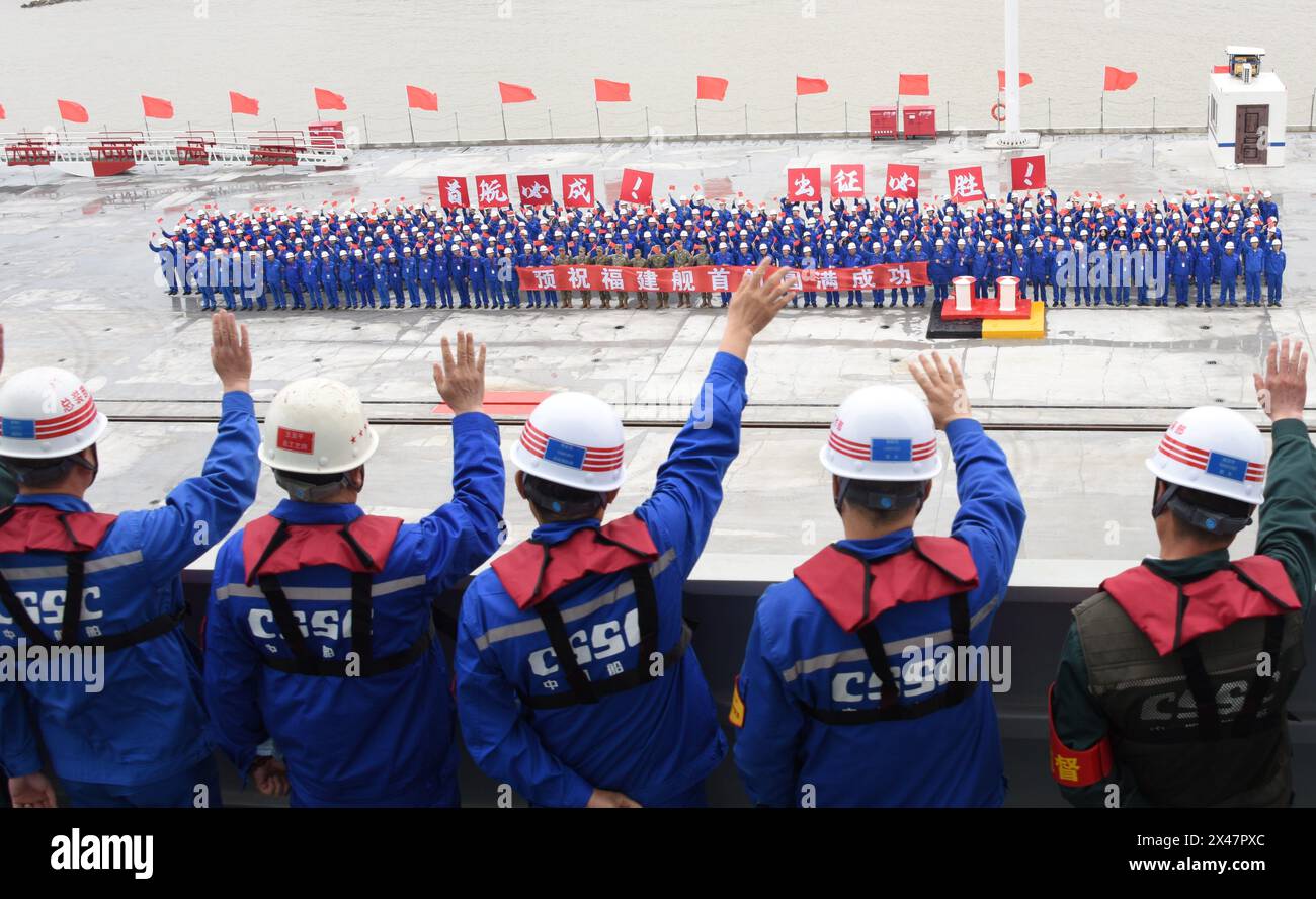 (240501) -- SHANGHAI, 1° maggio 2024 (Xinhua) -- la gente saluta i membri del personale che partecipano alle prove in mare della terza portaerei cinese, la Fujian, in un molo nella Cina orientale di Shanghai il 1° maggio 2024. La terza portaerei cinese, la Fujian, è partita per le prime prove in mare mercoledì mattina. Le prove in mare testeranno principalmente l'affidabilità e la stabilità dei sistemi elettrici e di propulsione della portaerei. Dal suo lancio nel giugno 2022, il Fujian ha completato le prove di ormeggio, i lavori di allestimento e le regolazioni delle attrezzature. Ha soddisfatto i requisiti tecnici per se Foto Stock
