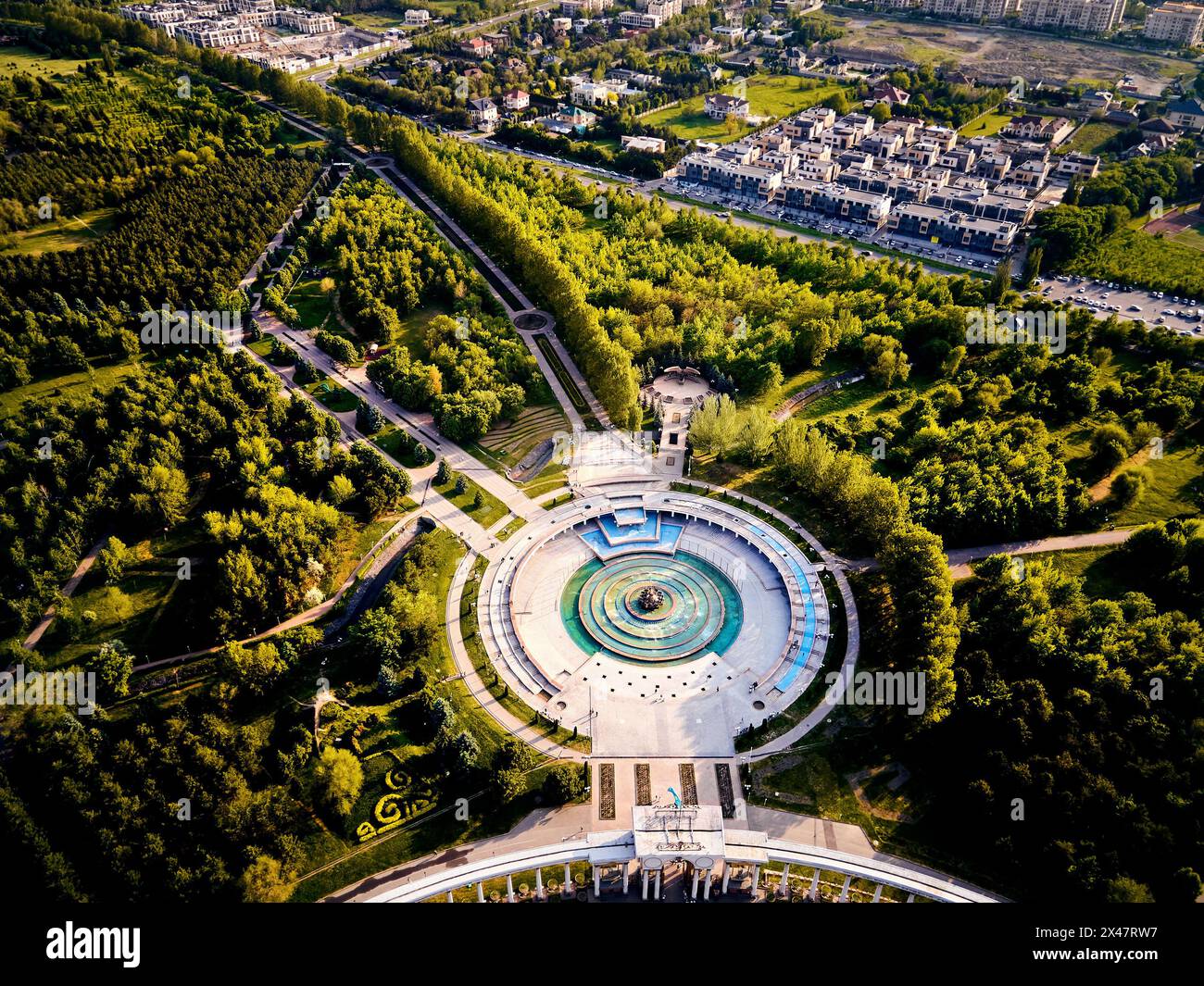Vista aerea dall'arco d'ingresso al parco del primo presidente di Almaty, Kazakistan. Fontana a forma di cerchio sulla piazza con arco dall'alto verso il basso. Foto Stock