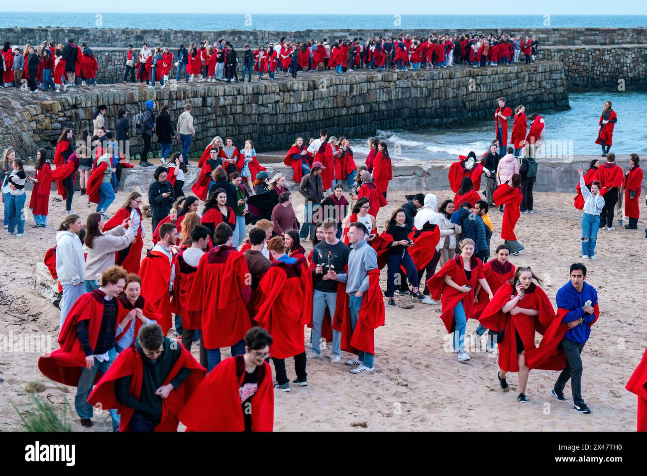 Gli studenti dell'Università di St Andrews, che indossano i loro tradizionali abiti rossi, prendono parte alla Gaudie, una processione attraverso la città e giù fino al molo. L'annuale Gaudie si svolge ogni 30 aprile per commemorare l'ex studente John Honey, che nel 1800 salvò i membri dell'equipaggio della Janet di Macduff che si era arenato al largo delle East Sands. Data foto: Martedì 30 aprile 2024. Foto Stock