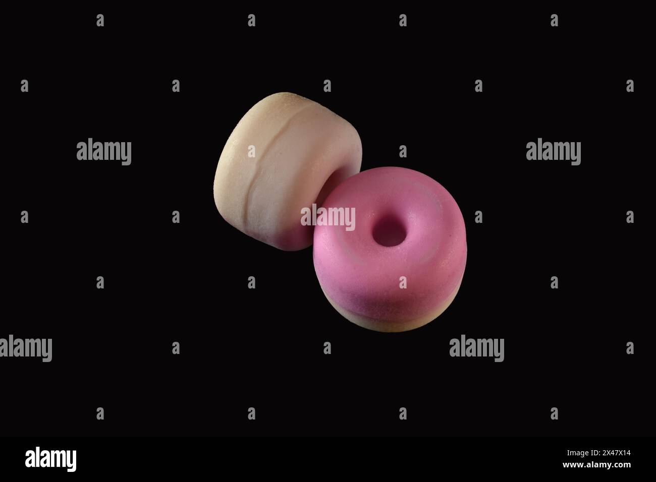 Su uno sfondo nero giacciono delle barre di sapone di colore rosa fatte a casa. Foto Stock