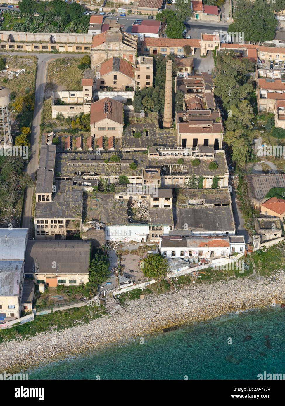 VISTA AEREA. Edifici abbandonati sulla costa della città di Palermo. Provincia di Palermo, Sicilia, Italia. Foto Stock