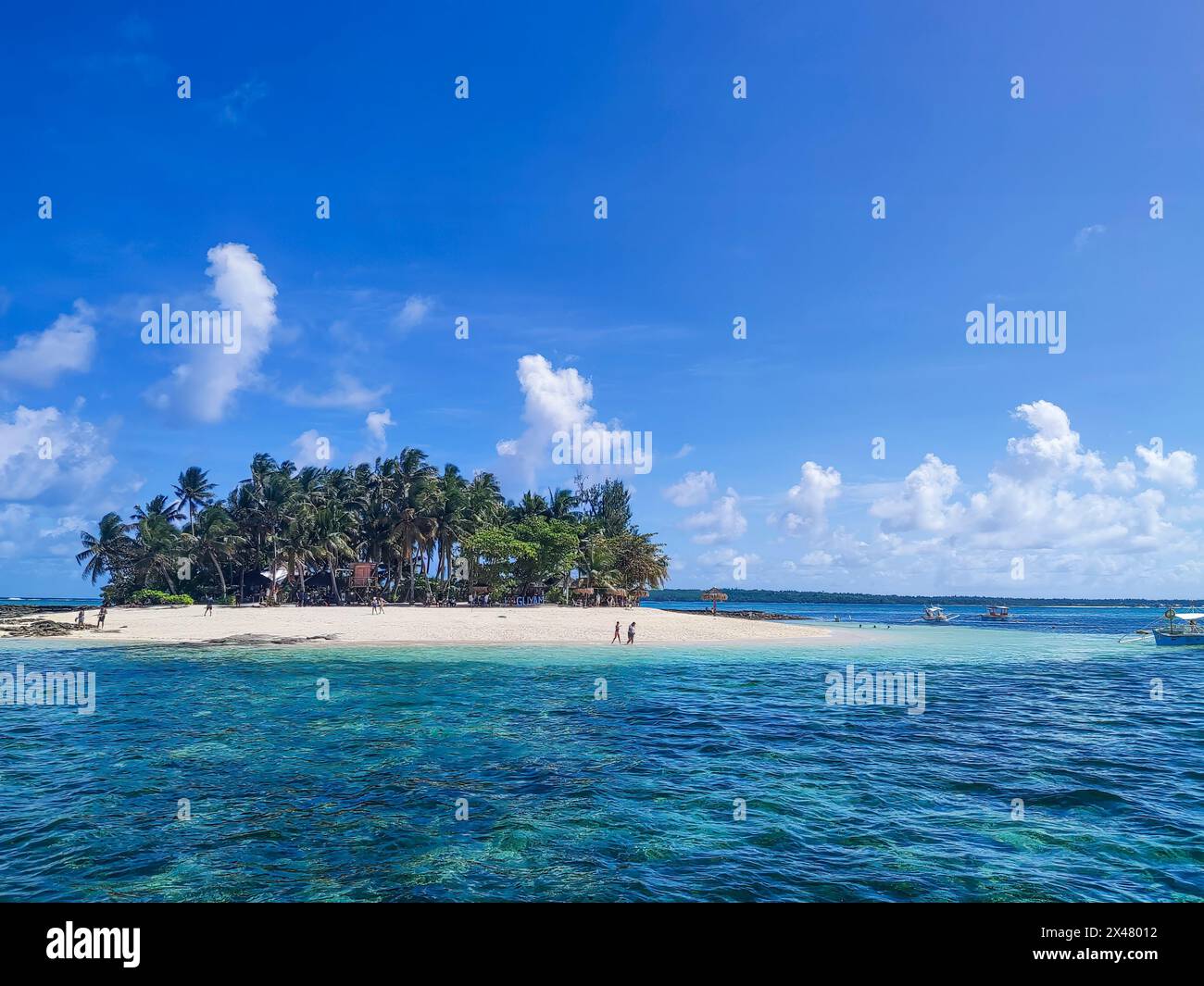 Turisti su una piccola isola di Siargao, Mindanao, Filippine, con acque turchesi incredibilmente chiare e trasparenti. Foto Stock