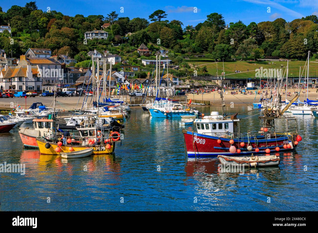 Una collezione di attraenti e colorati pescherecci e imbarcazioni da diporto nel porto di Lyme Regis, Jurassic Coast, Dorset, Inghilterra, Regno Unito Foto Stock