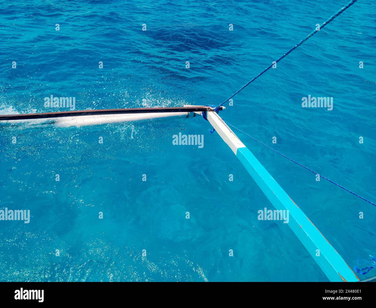 Primo piano degli stabilizzatori di bambù di una banca filippina o bangka sulle acque cristalline di Siargao. Foto Stock