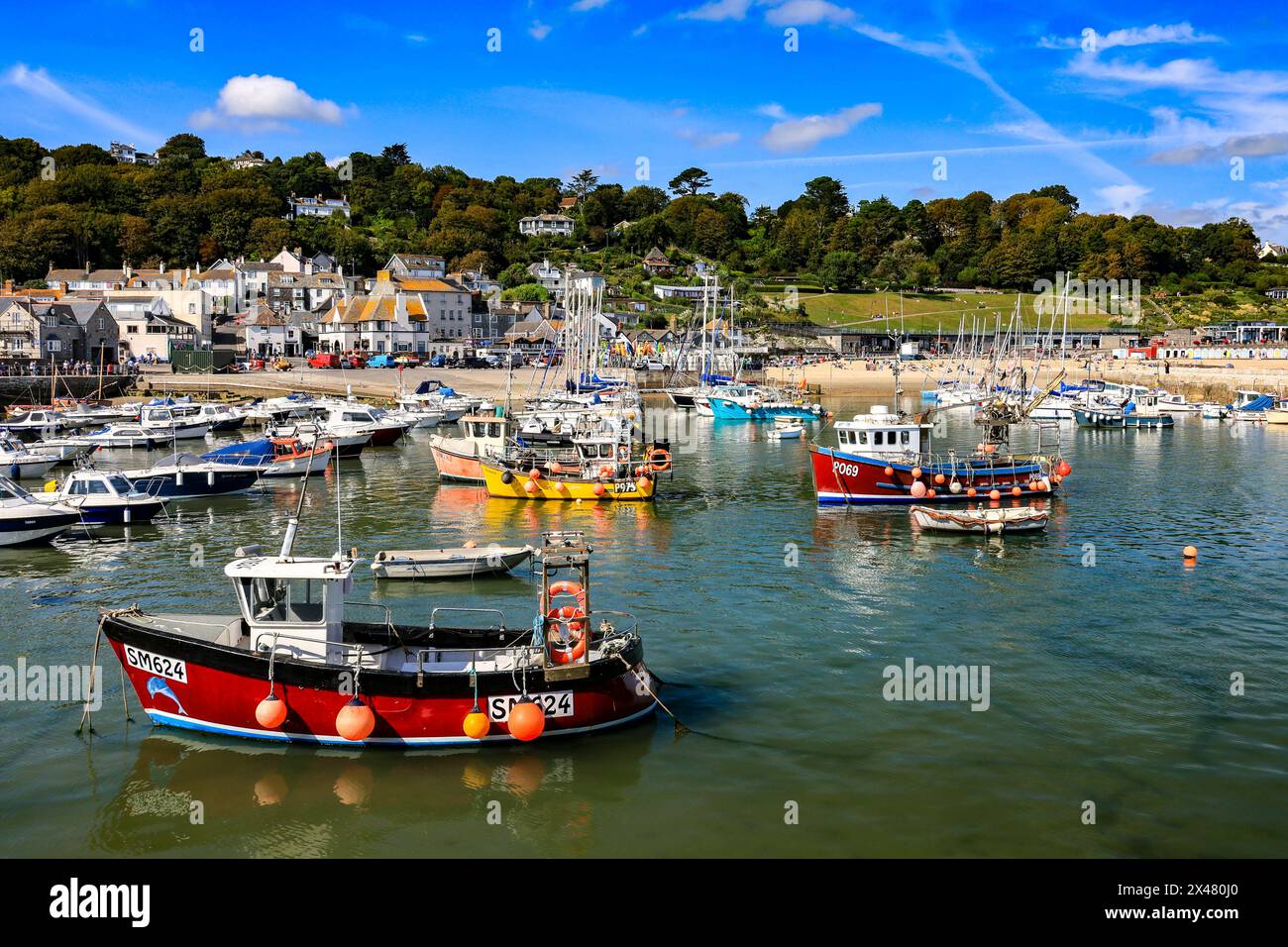 Una collezione di attraenti e colorati pescherecci e imbarcazioni da diporto nel porto di Lyme Regis, Jurassic Coast, Dorset, Inghilterra, Regno Unito Foto Stock