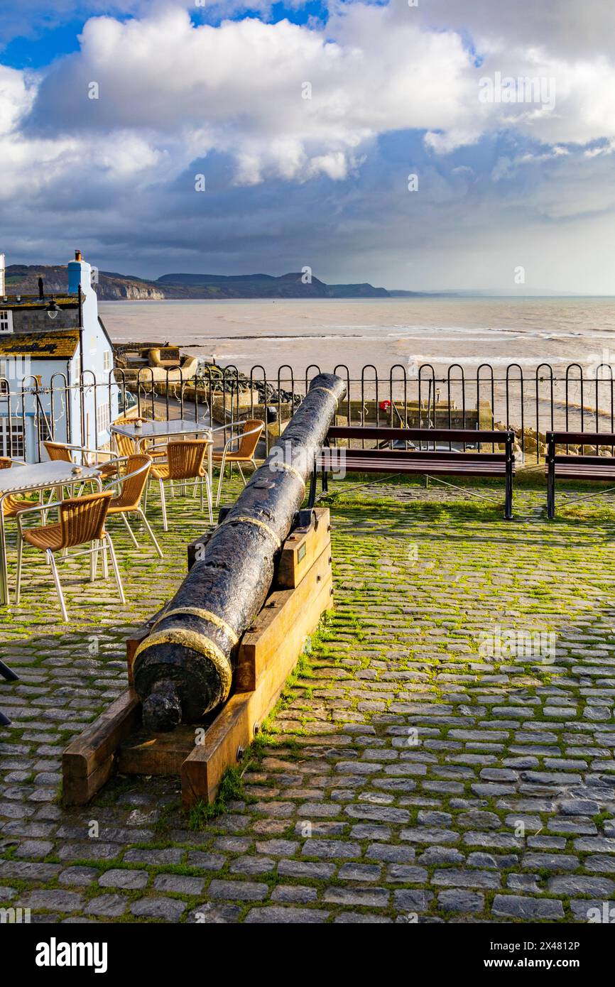 Uno storico cannone conservato e montato per ammirare la Jurassic Coast e la Lyme Bay dalla Bell Cliff Terrace a Lyme Regis, Dorset, Inghilterra, Regno Unito Foto Stock