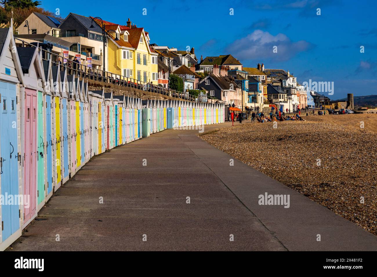 Il sole invernale illumina le colorate capanne lungo il lungomare di Lyme Regis, Dorset, Inghilterra, Regno Unito Foto Stock