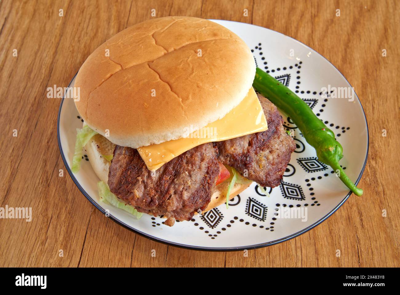 Hamburger di maiale su un piatto decorato su un tavolo in legno Foto Stock