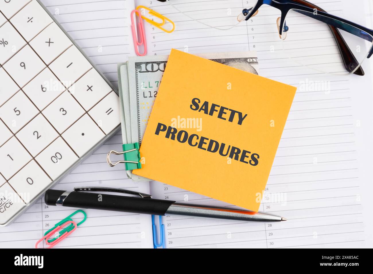 Concetti di sicurezza e salute sul lavoro. PROCEDURE DI SICUREZZA su un adesivo giallo con il denaro su un notebook aziendale Foto Stock