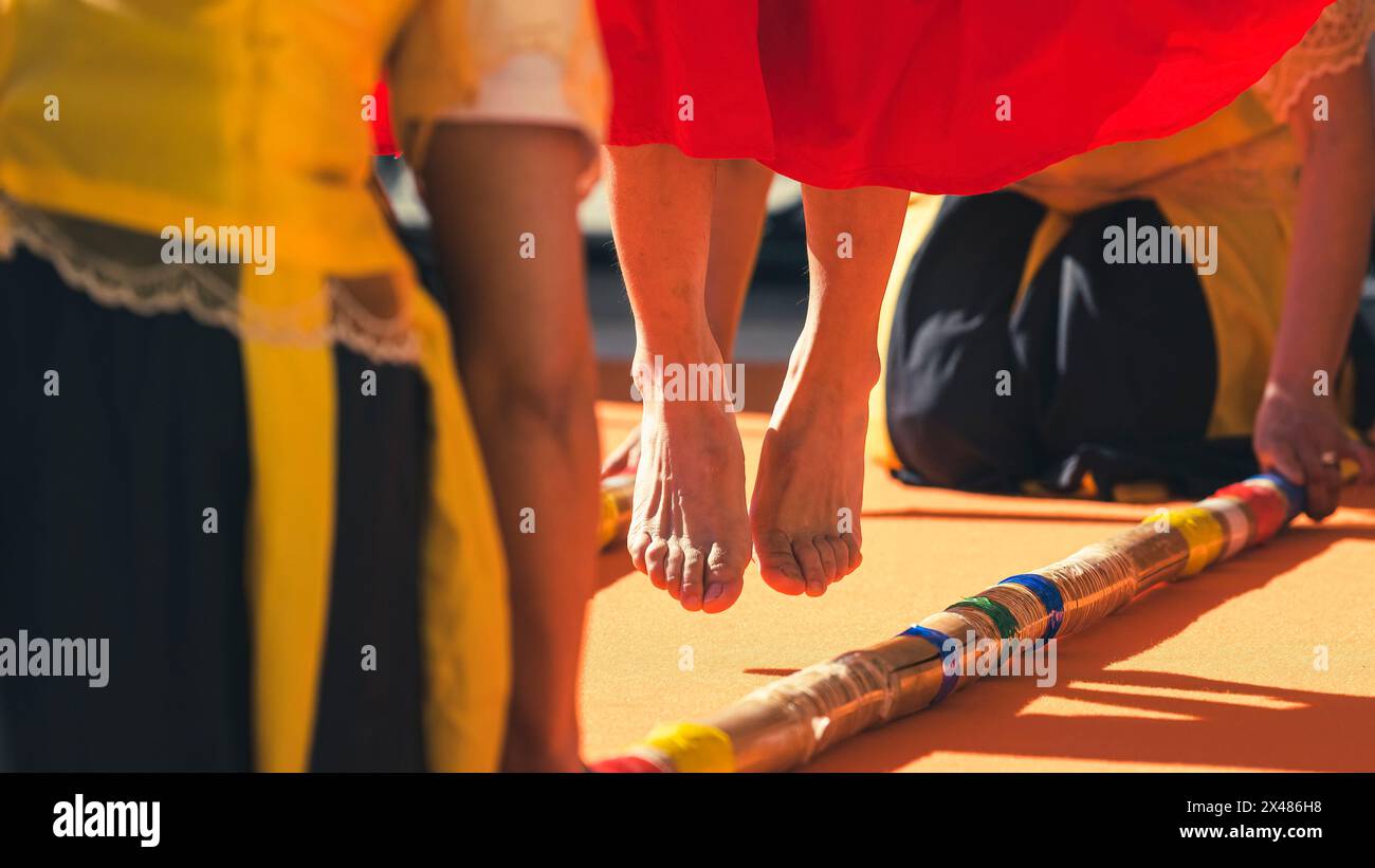 Saltando i piedi eseguendo Tinikling, probabilmente la danza popolare più popolare delle Filippine. Foto Stock