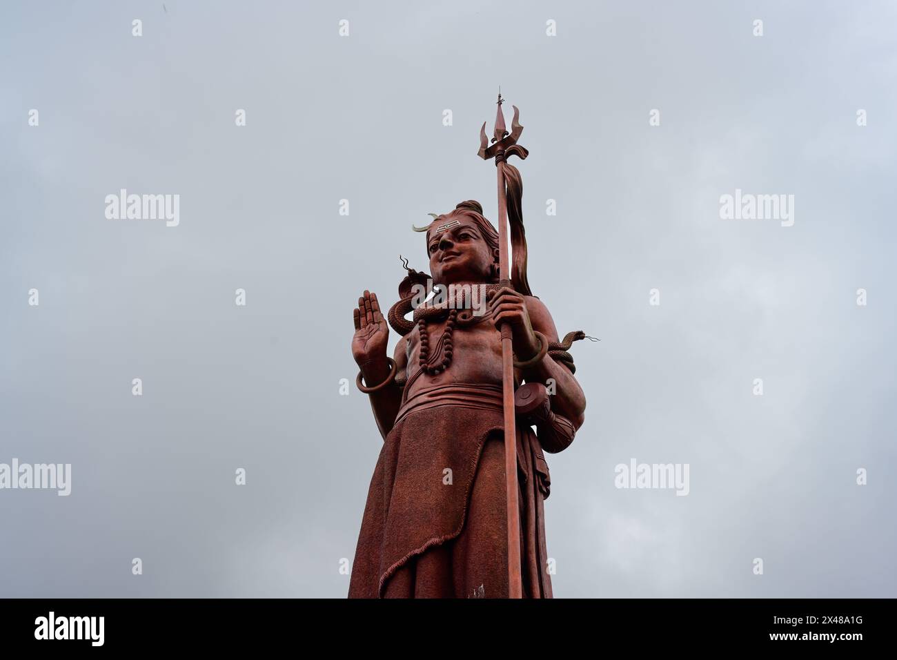 Statua del Signore Rosso Shiva con Tridente a Ganga Talao o Grand Bassin Mauritius Foto Stock