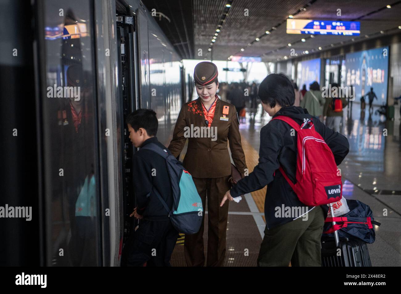 Pechino, la provincia cinese di Hubei. 1 maggio 2024. Un conduttore del treno guida i passeggeri a salire a bordo del treno superveloce G66 sulla piattaforma della stazione ferroviaria di Wuhan a Wuhan, nella provincia di Hubei della Cina centrale, il 1° maggio 2024. Le festività cinesi del maggio durano dal 1° al 5 maggio di quest'anno. La rete ferroviaria del paese ha assistito a un picco di viaggi il primo giorno della vacanza. Crediti: Wu Zhizun/Xinhua/Alamy Live News Foto Stock