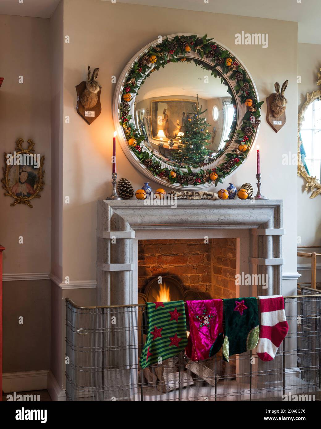 Le calze natalizie sono appese alla guardia del fuoco nella casa di famiglia Dorset, Inghilterra, Regno Unito Foto Stock
