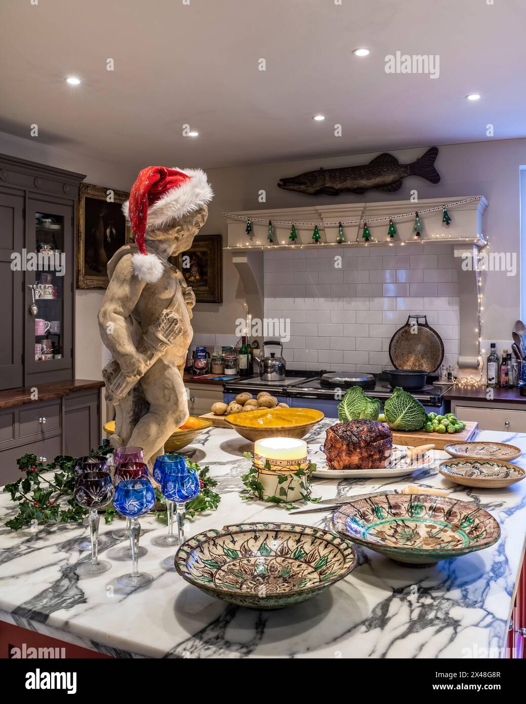 Statua in cappello di babbo natale con preparazione del cibo nella casa della famiglia Dorset a Natale, Inghilterra, Regno Unito Foto Stock