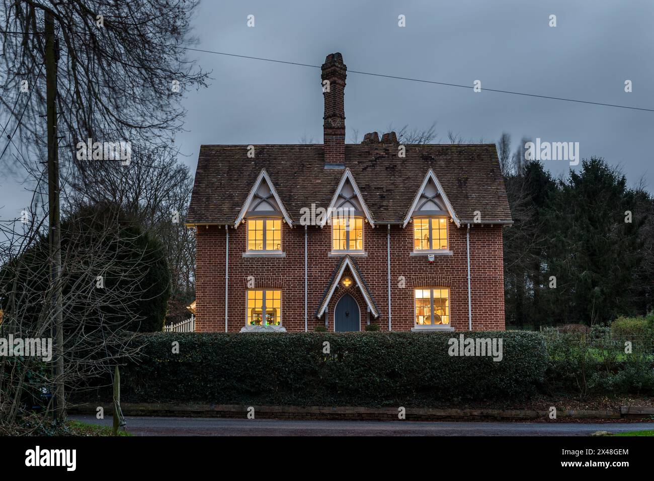 Finestre illuminate nella casa di famiglia Dorset a Natale, Inghilterra, Regno Unito Foto Stock