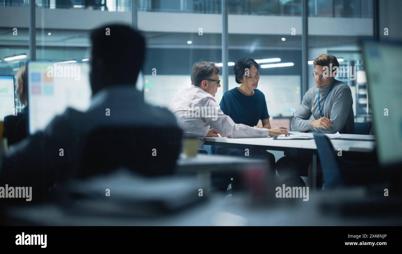 Diversi team di manager che lavorano e discutono nel moderno Big City Office. I colleghi lavorano su nuove opportunità di business, il Consiglio di amministrazione tiene una riunione e parla di investire nel futuro. Foto Stock