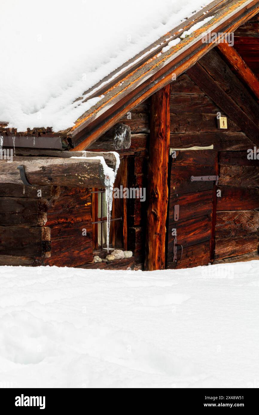 Dettaglio di un piccolo cottage in legno ricoperto di neve Foto Stock