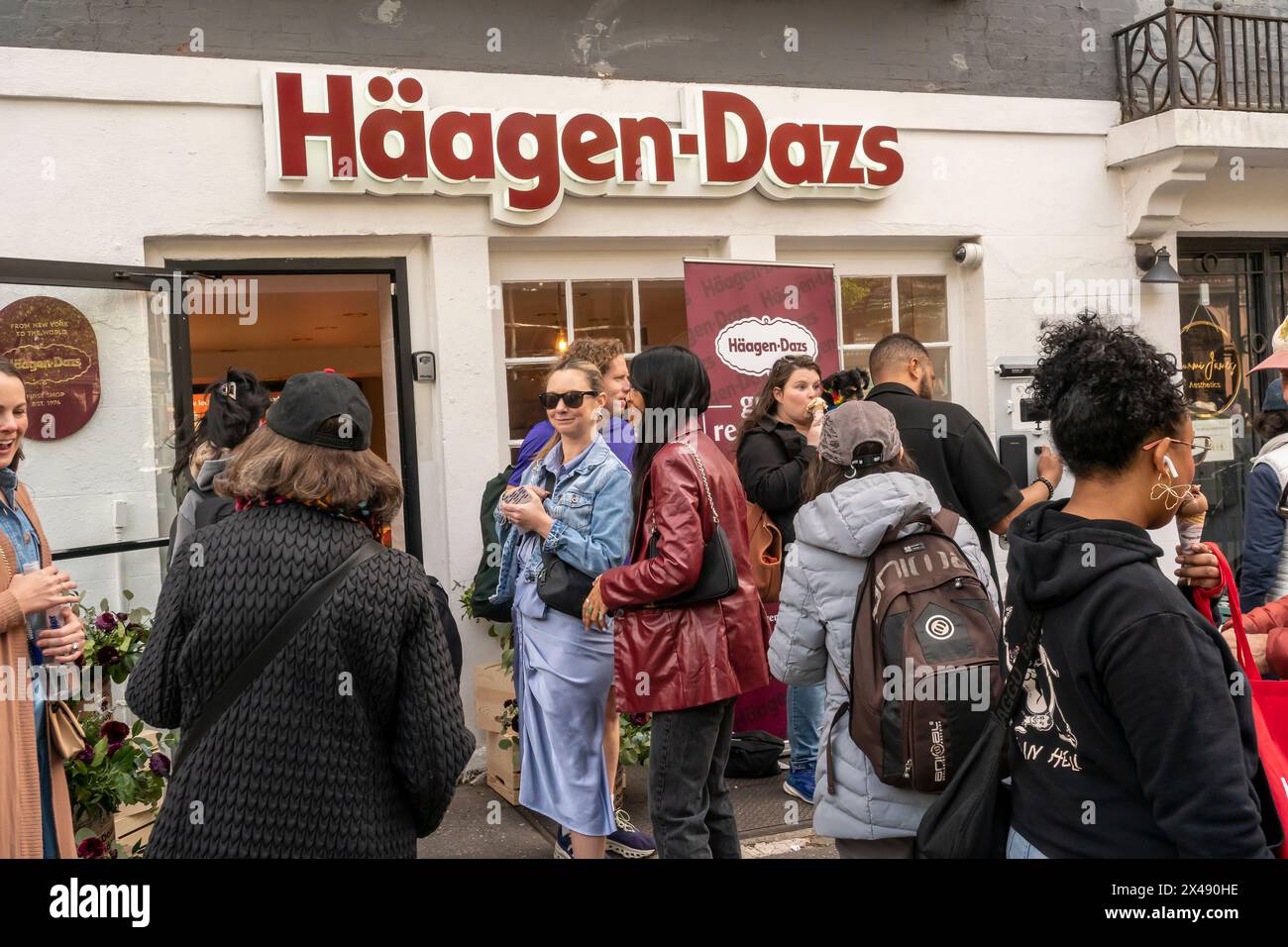 Le persone si schierano per acquistare gratuitamente il gelato HŠagen-Dazs per celebrare la riapertura del loro negozio a Brooklyn Heights a New York sabato 27 aprile 2024. Il negozio è il primo negozio aperto dalla gelateria, nel 1976. HŠagen-Dazs è un marchio della General Mills. ( © Richard B. Levine) Foto Stock