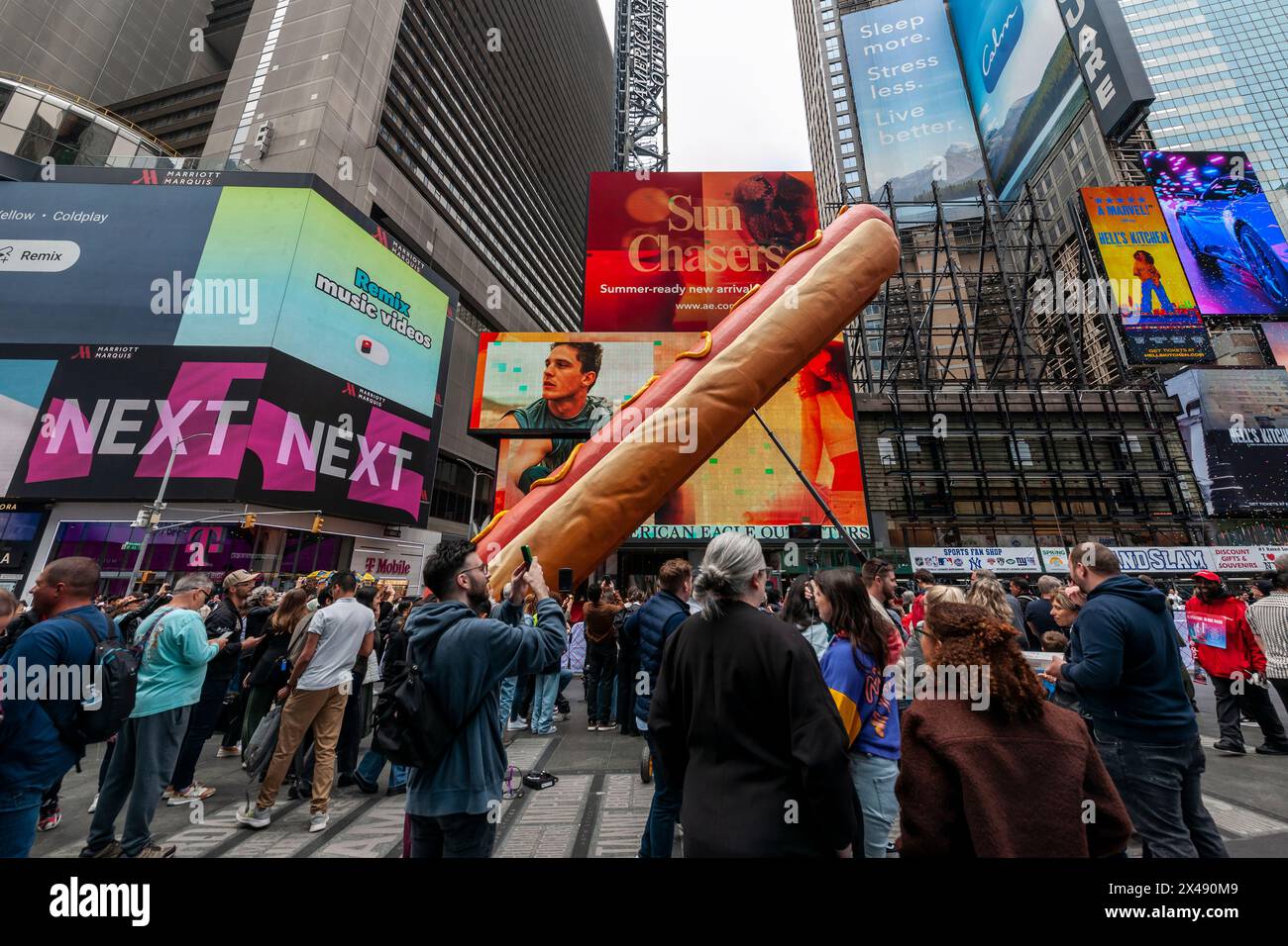 “Hot Dog in the City”, degli artisti Jen Catron e Paul Outlaw a Times Square a New York martedì 30 aprile 2024. La scultura animatronica di hot dog lunga 65 metri si solleva e eiacula coriandoli a mezzogiorno ogni giorno. L'installazione sarà visibile fino al 13 giugno.(© Richard B. Levine) Foto Stock