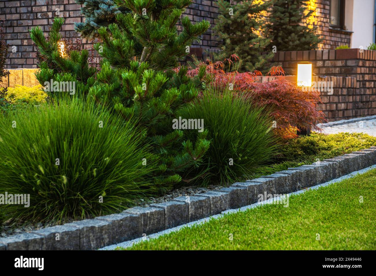 Palo luminoso per esterni a LED sul retro e giardino Rockery stagionato. Foto Stock