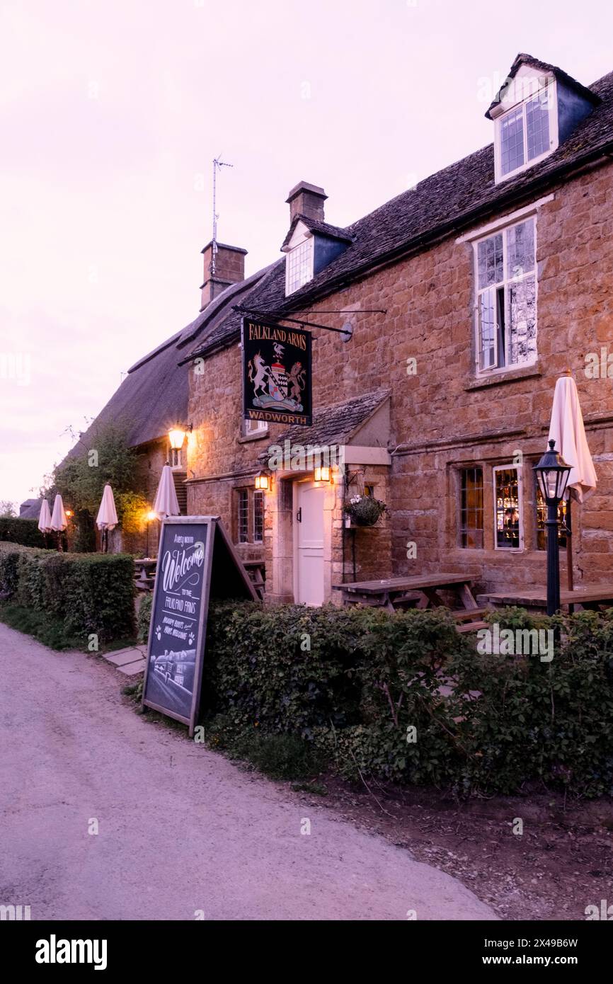 La casa pubblica Falkland Arms al crepuscolo nel tranquillo villaggio Cotswold di Great Tew nell'Oxfordshire. Foto Stock