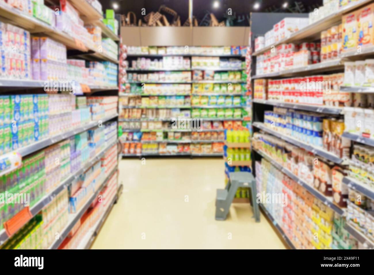 Sfocatura delle lenti del corridoio del supermercato con il prodotto del contenitore del latte sugli scaffali Foto Stock