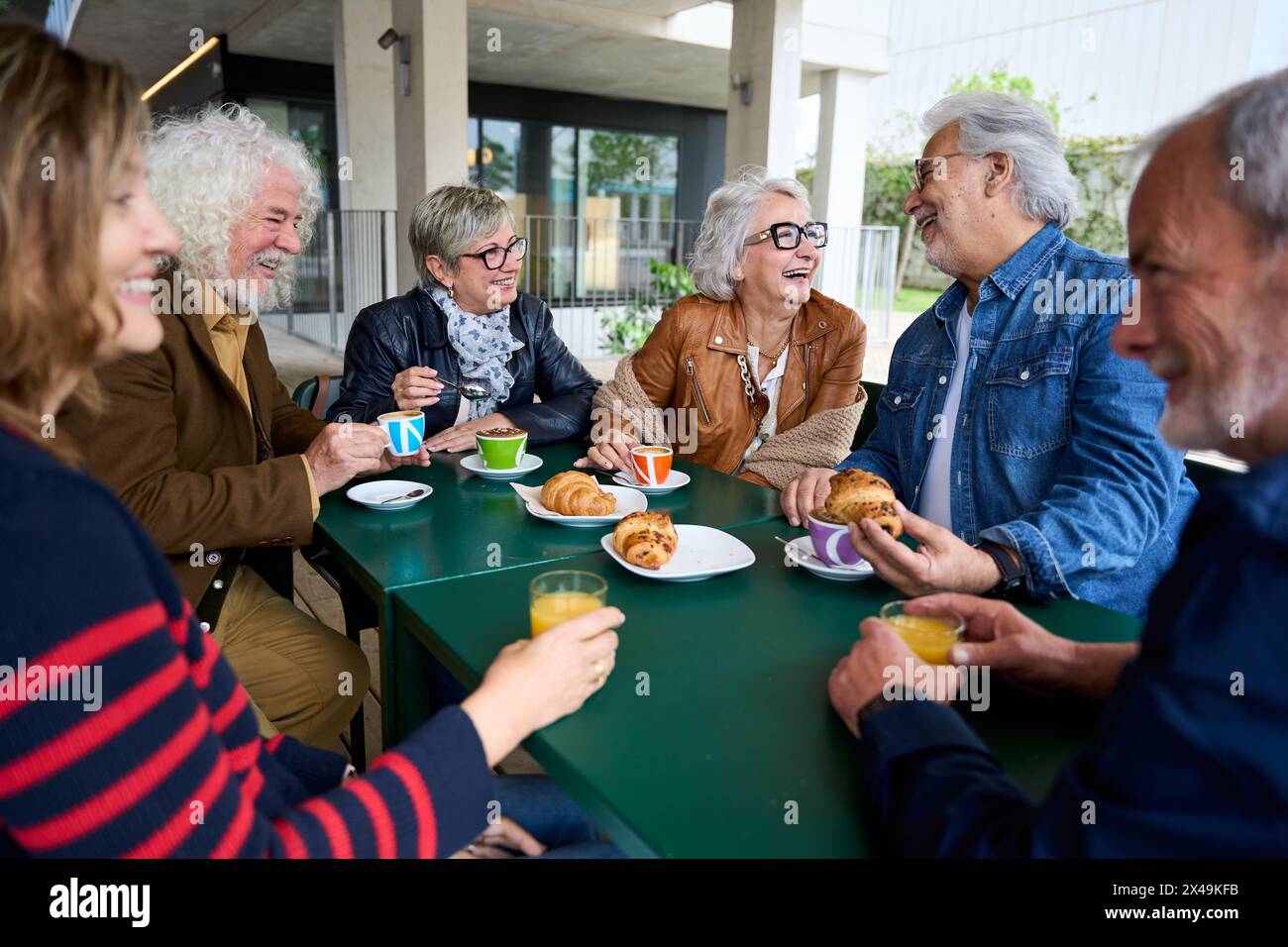 Gruppo di amici di capelli grigi maturi al bar sul tetto. Persone anziane che parlano e si divertono Foto Stock