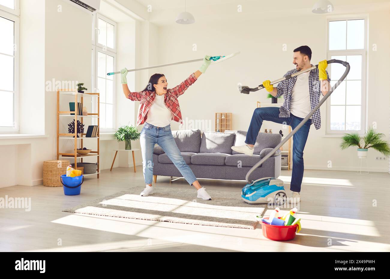 Una coppia felice pulisce e gioca insieme a casa Foto Stock