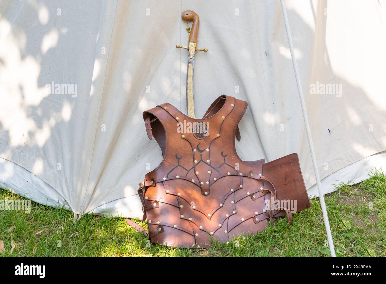 Spada turca medievale, sciabola e armatura in pelle in una tenda in un campo militare Foto Stock