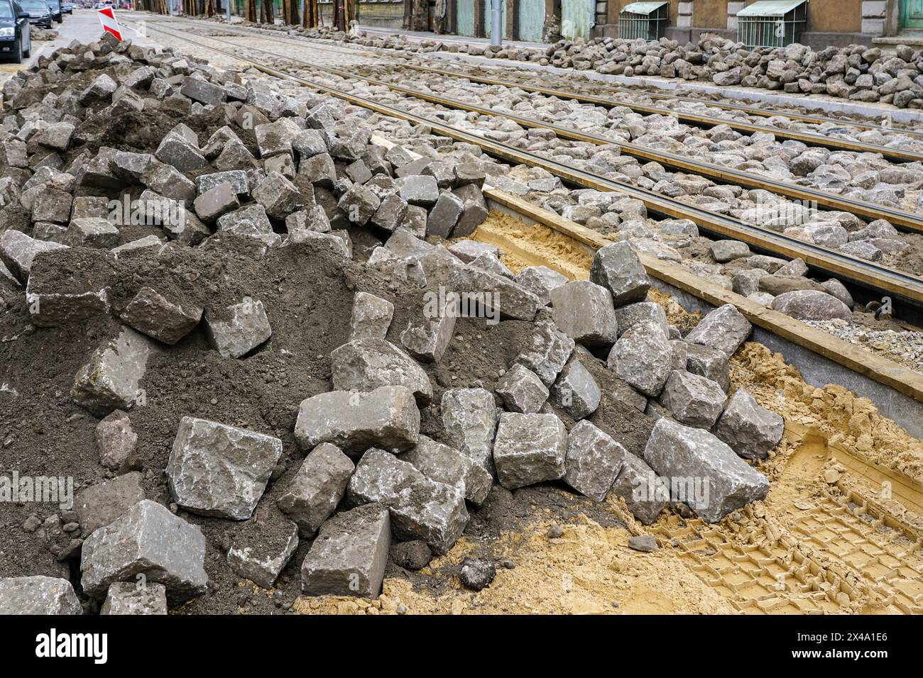 Pavimentazione stradale con pietre storiche martellate di granito dopo la ricostruzione della strada e la sostituzione dei binari del tram Foto Stock