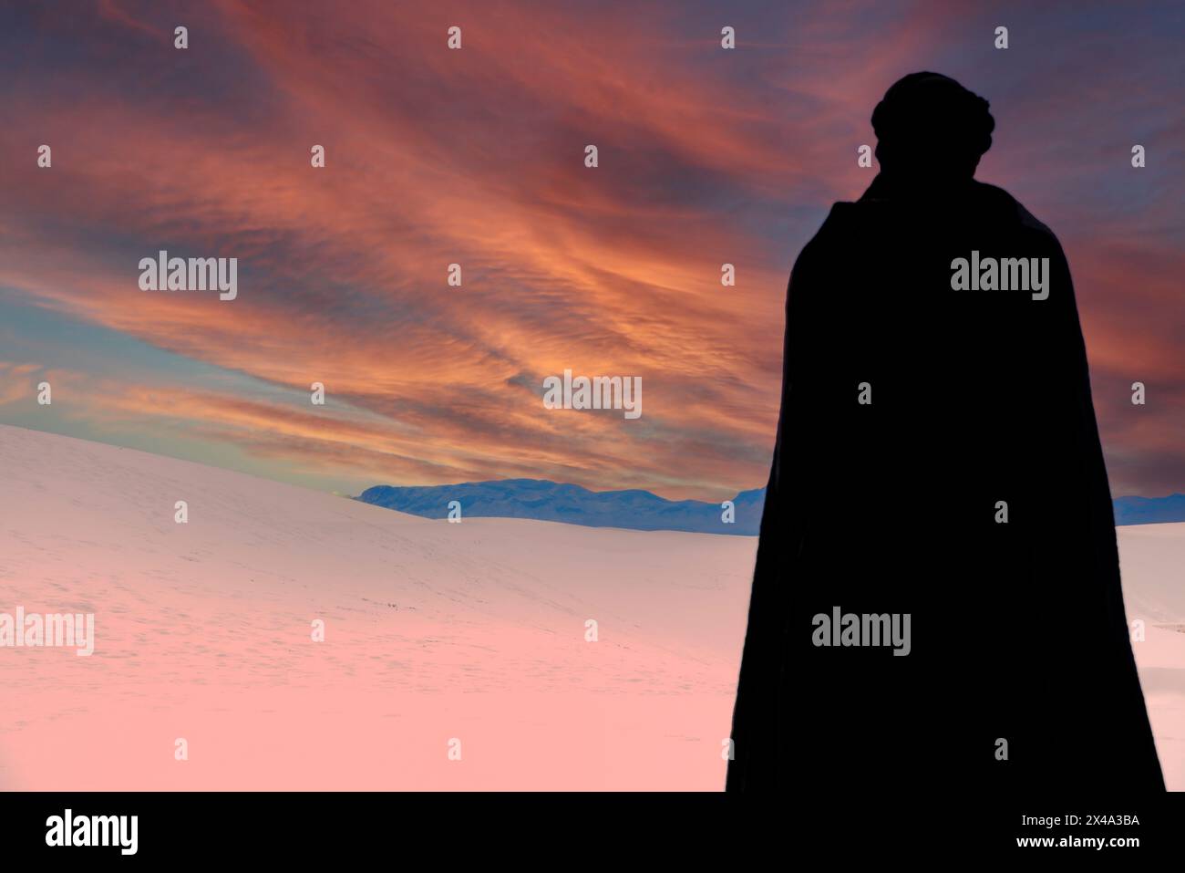 Una persona che indossa un mantello nero e un copricapo turbante nero contempla la vista delle dune di gesso tra il cielo al White Sands NP di Alamogordo, NEW MEXICO Foto Stock