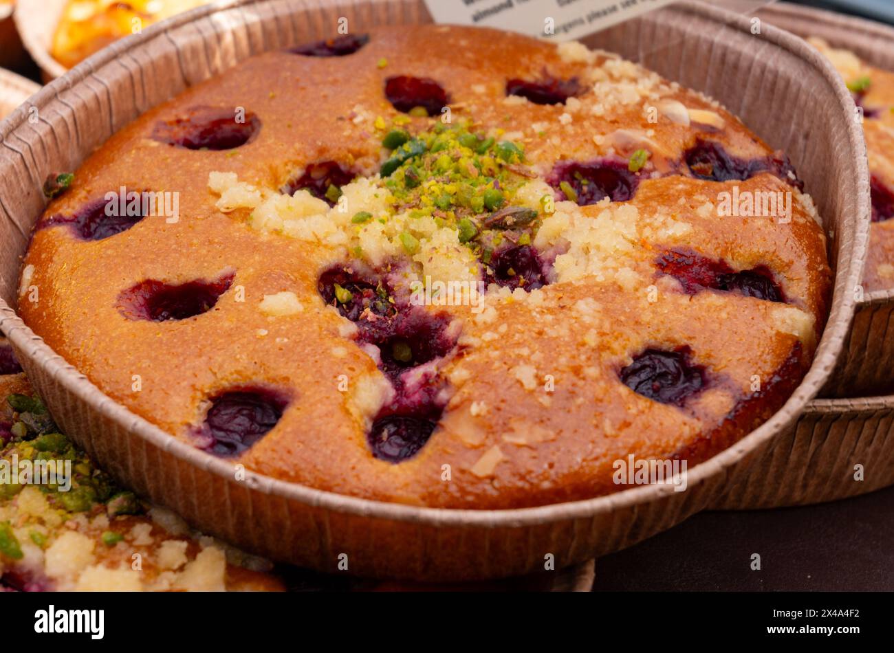 Dolci dolci, torte di mele rustiche biologiche, ciliegie, torte di mandorle sul mercato alimentare di Londra, Regno Unito Foto Stock