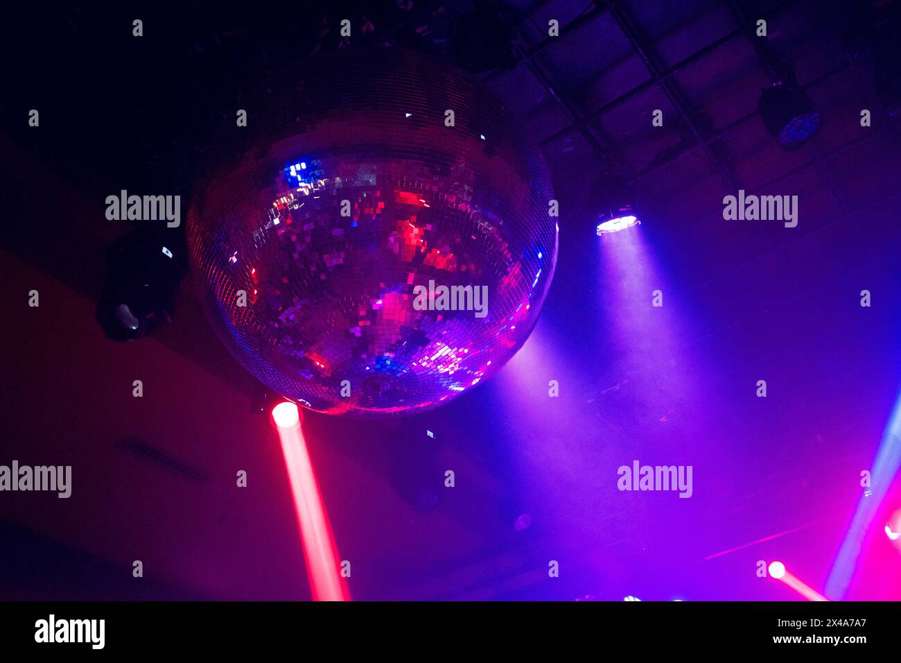 Le luci rosse e blu si muovono al ritmo della musica sul soffitto di un nightclub o di una sala da concerto, creando un'atmosfera da ballo festosa Foto Stock