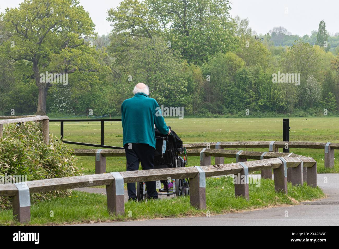 Uomo anziano che si prende cura della moglie disabile su una sedia a rotelle, Inghilterra, Regno Unito. Concetto: Assistenti non retribuiti, assistenza inadeguata per anziani e disabili Foto Stock