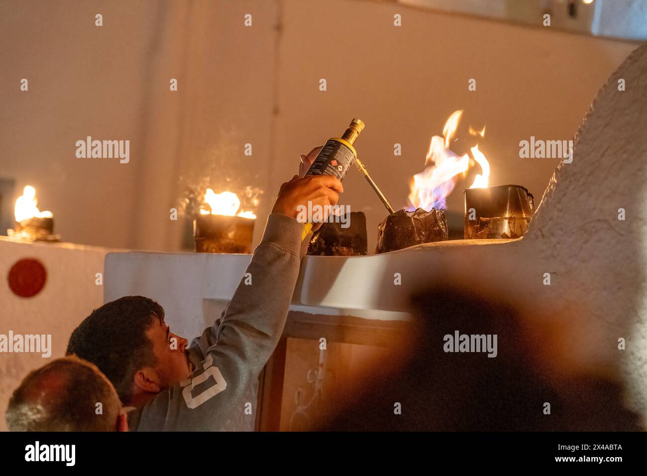 Un bianco caucasico accende una delle migliaia di lanterne come parte delle usanze locali del venerdì Santo e dell'Epitaph Foto Stock