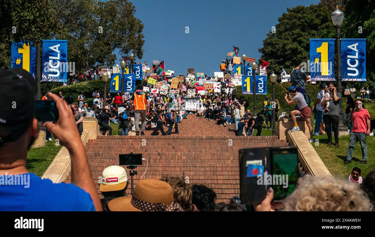 Los Angeles, Stati Uniti. 1 maggio 2024. Persone che scattano foto e video sui loro telefoni di studenti manifestanti seduti sui gradini di Janss nel campus dell'UCLA. Un accampamento di protesta contro la guerra a Gaza è stato istituito sul Royce Quad nel campus dell'UCLA, l'Università della California, Los Angeles. I manifestanti hanno allestito tende e cartelli sul quad per protestare contro la guerra tra Israele e Palestina. Crediti: Stu Gray/Alamy Live News. Foto Stock