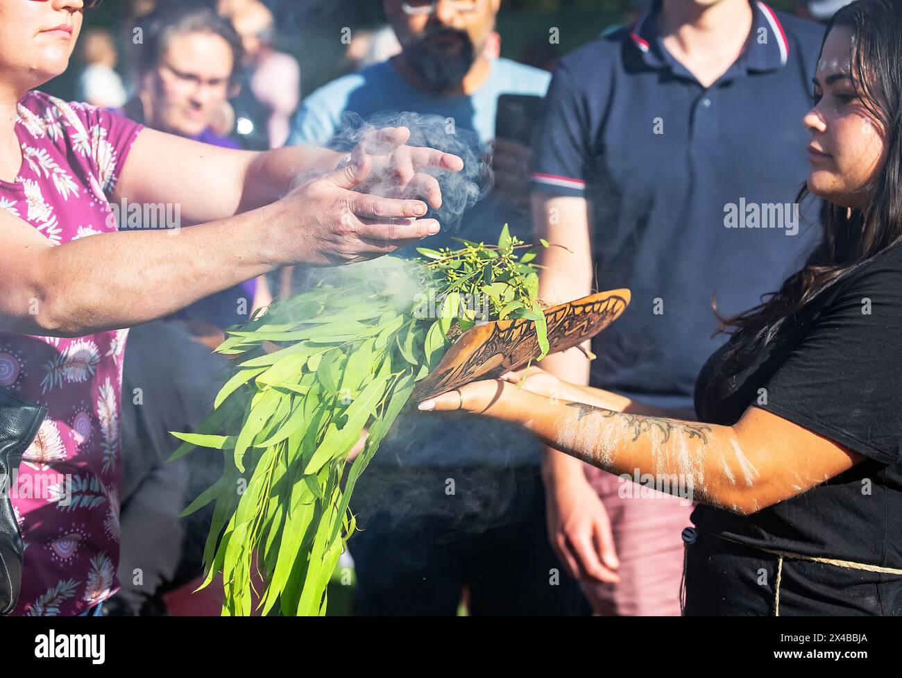 Fuoco rituale con ramo in fiamme verdi, fumo e fuoco, il rito rituale del fumo in un evento della comunità indigena in Australia Foto Stock