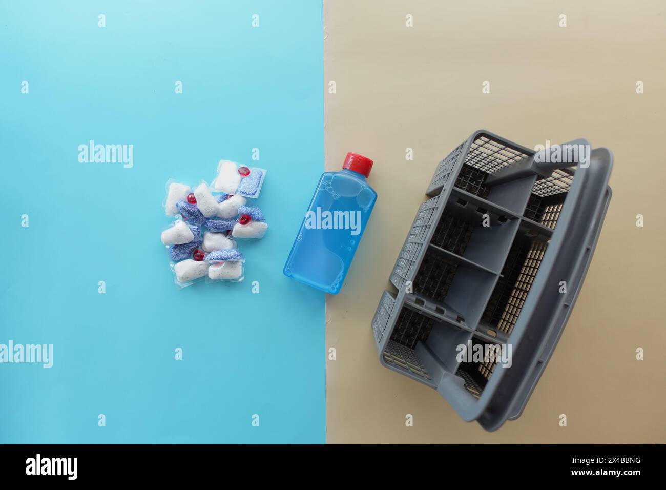 Una pila di compresse per lavastoviglie e una bottiglia di detergente su sfondo blu Foto Stock