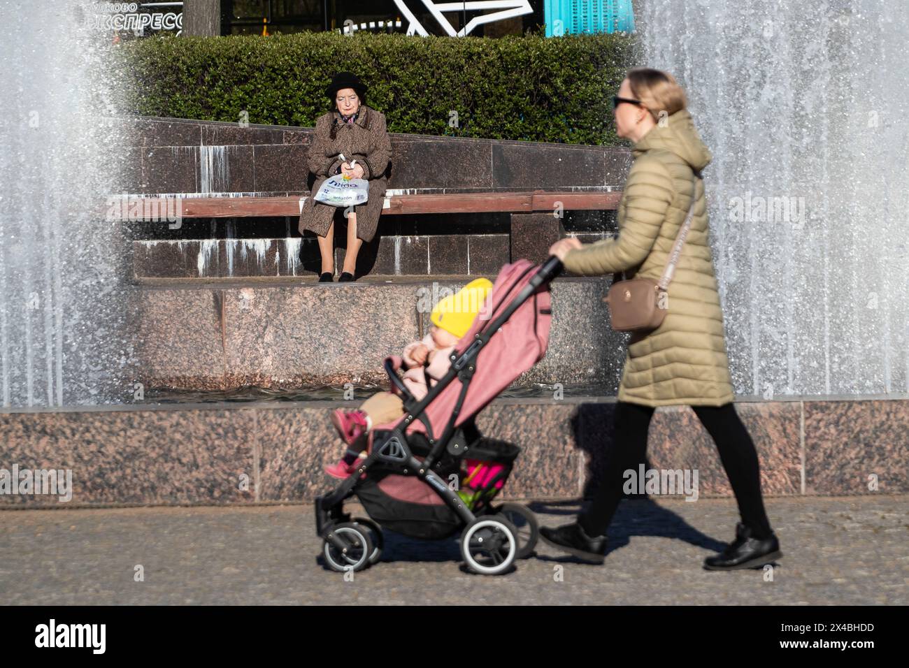 San Pietroburgo, Russia. 1° maggio 2024. Una donna spinge un bambino in un passeggino lungo Piazza Moskovskaya sullo sfondo del complesso delle fontane in una giornata calda a San Pietroburgo. (Foto di Artem Priakhin/SOPA Images/Sipa USA) credito: SIPA USA/Alamy Live News Foto Stock
