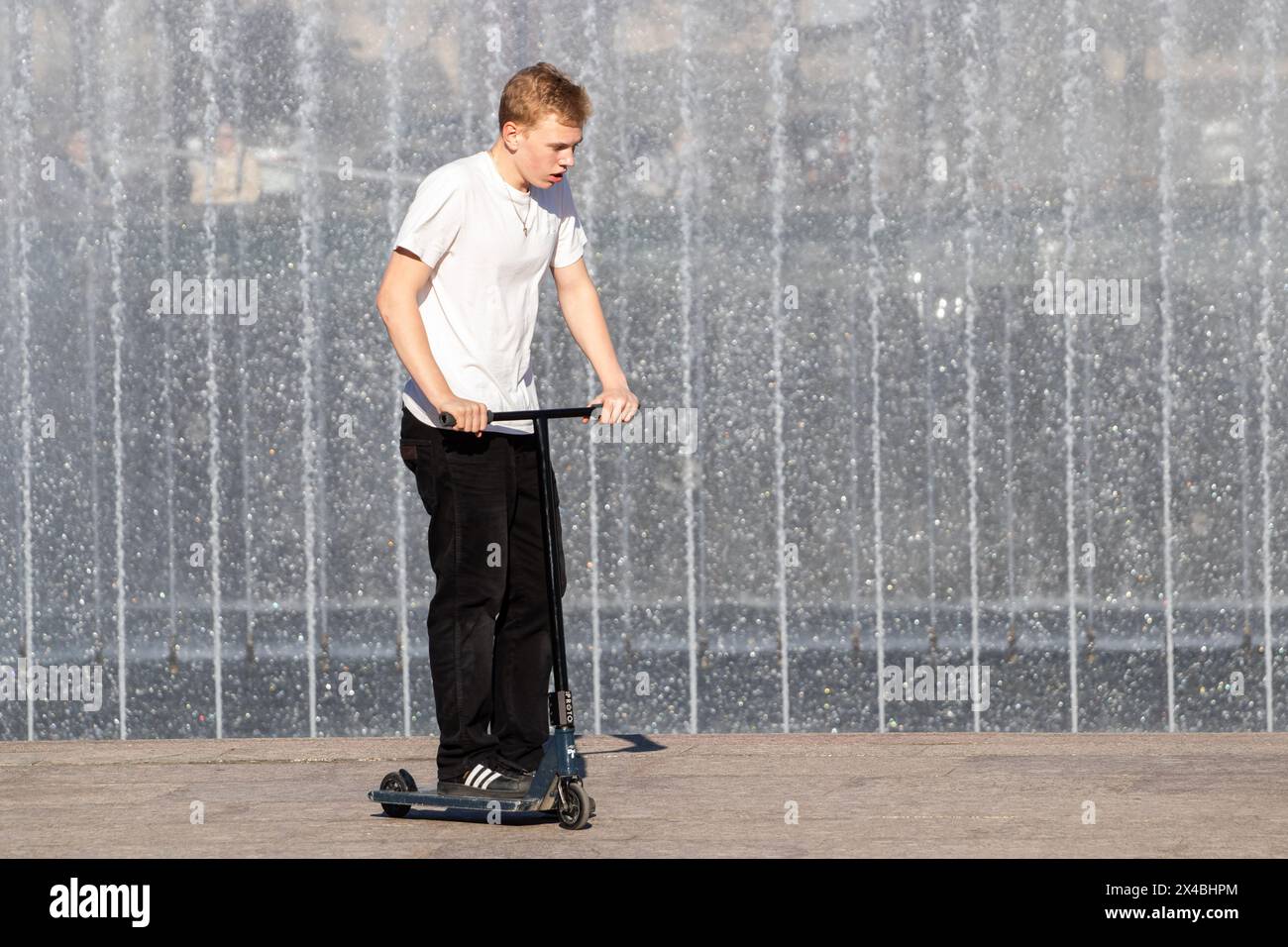 San Pietroburgo, Russia. 1° maggio 2024. Un uomo guida uno scooter in Piazza Moskovskaya sullo sfondo del complesso delle fontane in una giornata calda a San Pietroburgo. Credito: SOPA Images Limited/Alamy Live News Foto Stock