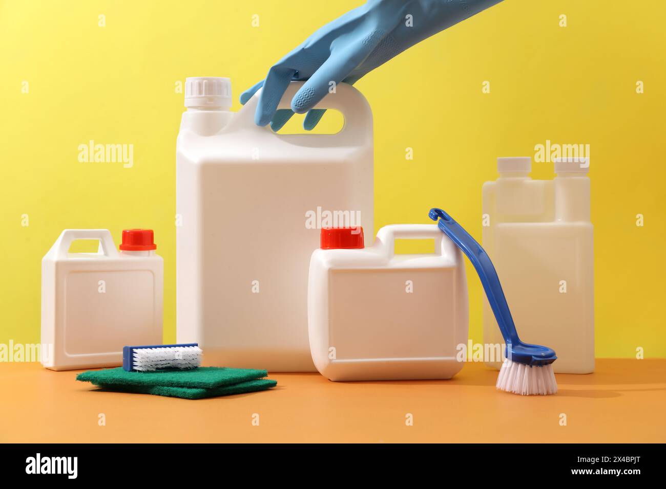 Ambiente minimo per la pulizia pubblicitaria di prodotti con etichetta vuota per il design del flacone mockup. Vista frontale di taniche bianche di dimensioni diverse con pennello, Foto Stock