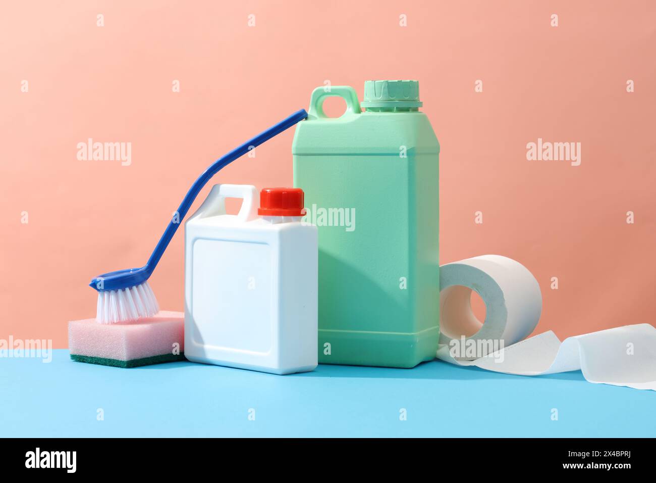 Scena minima per la pulizia pubblicitaria di un prodotto con bottiglia mockup per il design. Taniche verdi e bianche decorate con spazzolino, spugne e pape Foto Stock