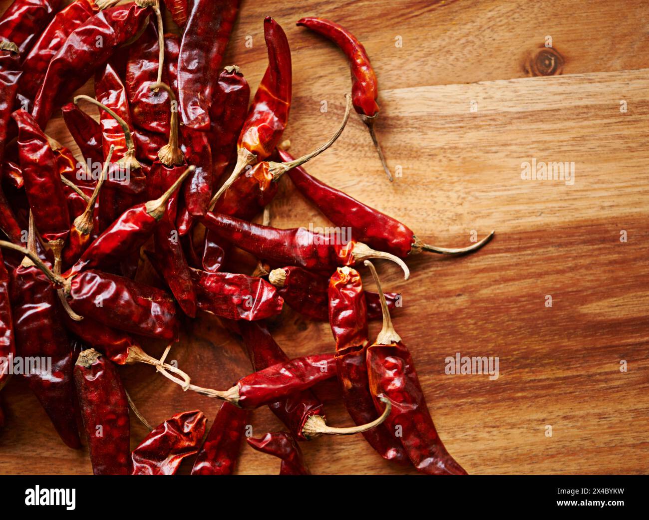 Peperoncini secchi, mockup e capsicum con spezie a bordo con ingredienti in cucina, cucina e cibo. Sopra, vista dall'alto e piccante con colore rosso per Foto Stock